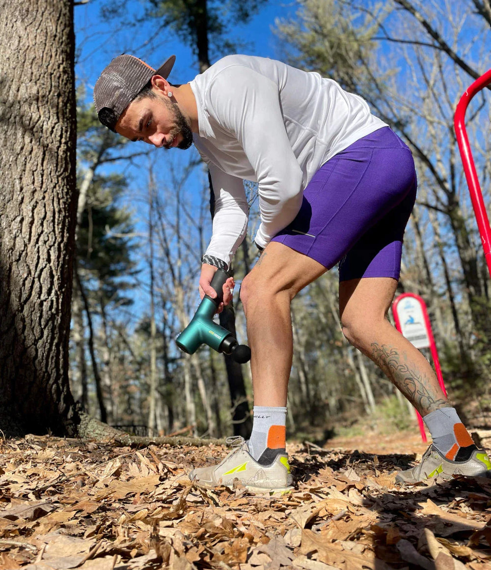 marathon runner using massage gun calves